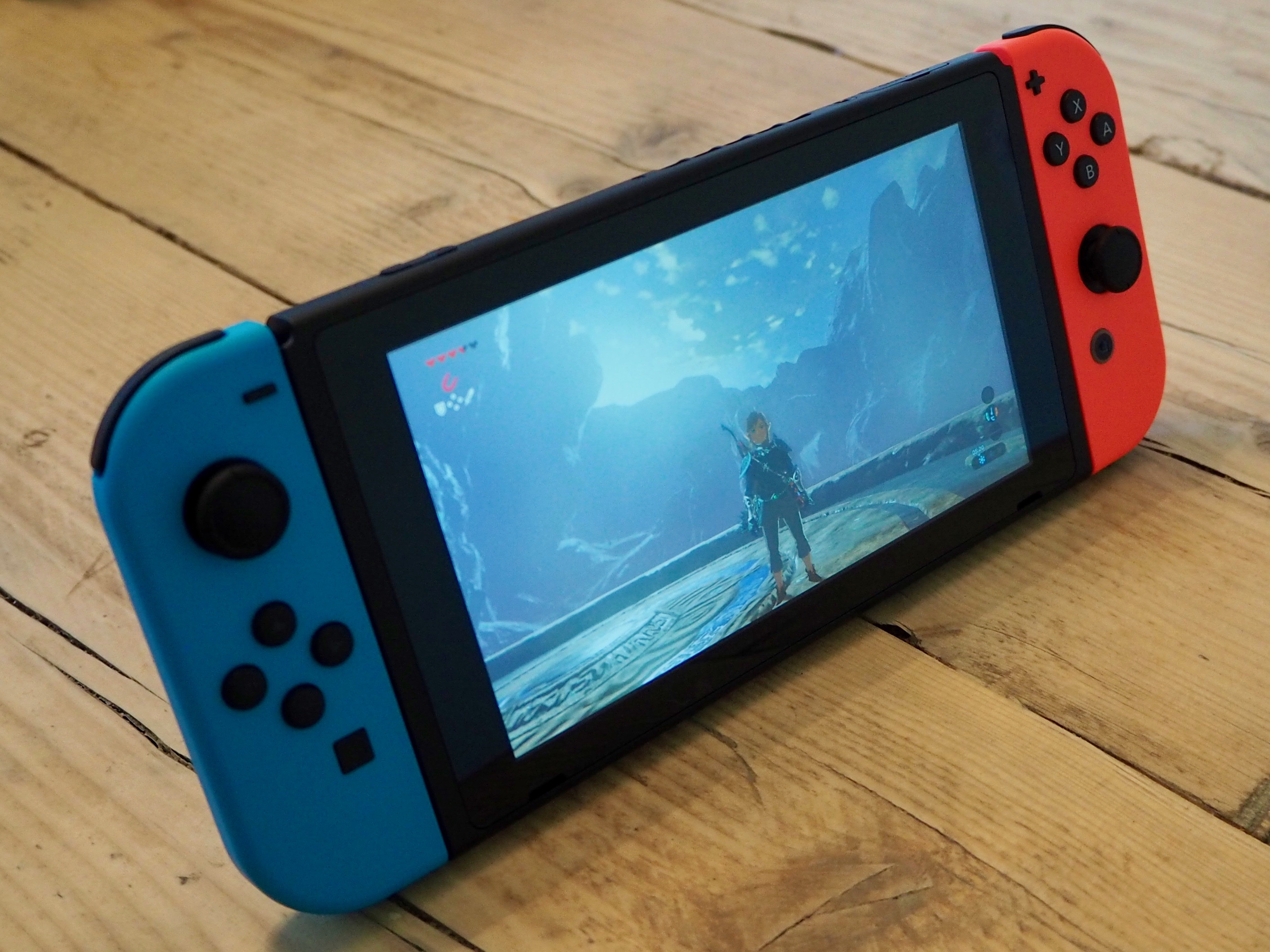 A Nintendo Switch console, showing the game The Legend of Zelda: Breath of the Wild on the screen
